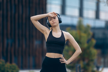 Blonde girl with earphones having break from workout.