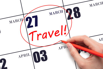 27th day of March. Hand drawing a red circle and writing the text TRAVEL on the calendar date 27...