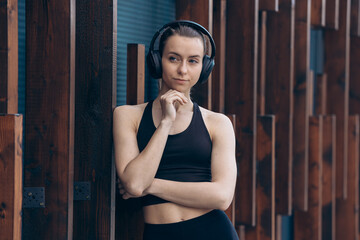 Girl with earphones standing, having break.