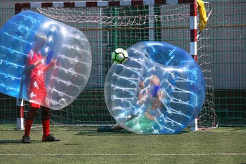 Deurstickers football ball game in inflatable transparent spheres. sports and entertainment. active recreation and hobbies © photosaint