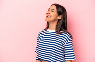 Young hispanic woman isolated on pink background relaxed and happy laughing, neck stretched showing teeth.