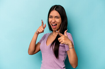 Fototapeta premium Young hispanic woman isolated on blue background pointing to front with fingers.