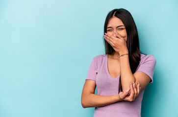 Young hispanic woman isolated on blue background laughing happy, carefree, natural emotion.