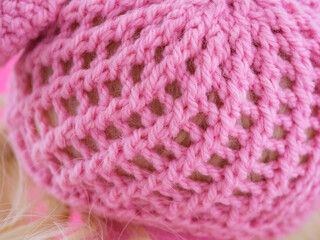 Close-up shot of a knitted pink hat on a doll head