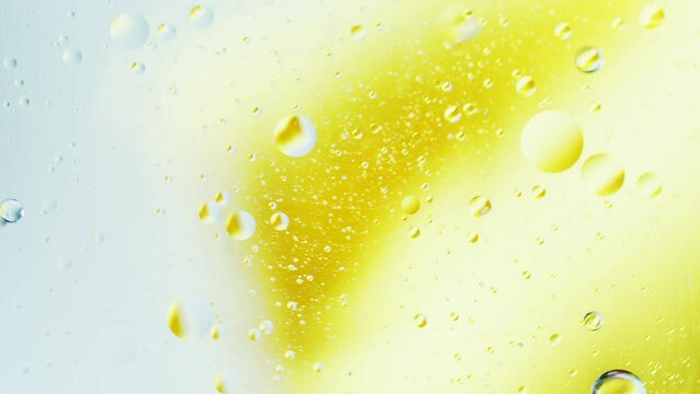 Real close up oil bubbles in water rotation with color gradient abstract mixing background.
