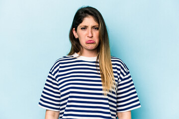 Young caucasian woman isolated on blue background sad, serious face, feeling miserable and...