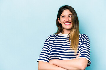 Fototapeta premium Young caucasian woman isolated on blue background smiling confident with crossed arms.