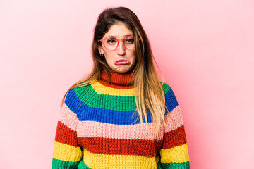 Young caucasian woman isolated on pink background sad, serious face, feeling miserable and displeased.