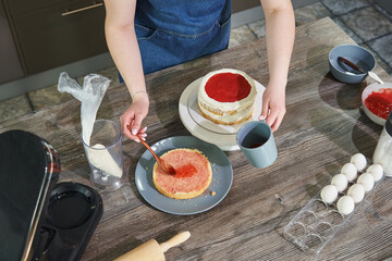 female hands soaks the cake. a woman prepares a birthday cake in the kitchen. cooking homemade cakes. home cake