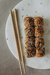 Baked sushi rolls on a marble board for serving