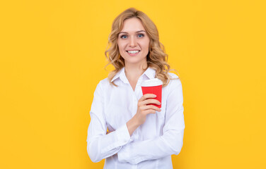 cheerful blonde woman with morning coffee cup on yellow background