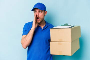 Fototapeta na wymiar Young caucasian delivery man isolated on blue background is saying a secret hot braking news and looking aside