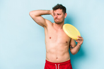 Young caucasian man playing with frisky isolated on blue background touching back of head, thinking and making a choice.