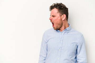 Young caucasian man isolated on white background shouting very angry, rage concept, frustrated.