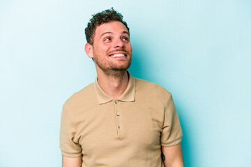 Fototapeta premium Young caucasian man isolated on blue background relaxed and happy laughing, neck stretched showing teeth.