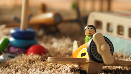 Many colorful baby wood toys on light brown color carpet which include ball, airplane, bus and others that helps development baby's EQ and IQ and make baby have a joyful moments.