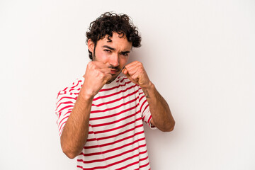 Fototapeta premium Young caucasian man isolated on white background throwing a punch, anger, fighting due to an argument, boxing.
