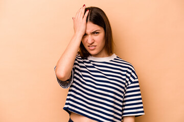 Young hispanic woman isolated on beige background forgetting something, slapping forehead with palm...
