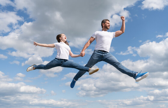happy family of father and daughter jump in sky