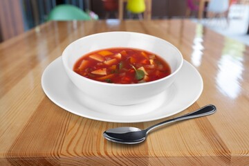 Tasty clear soup with beef slices and vegetables. Served in bowl on desk