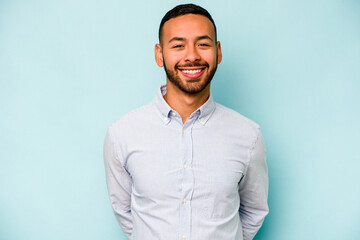 Young hispanic man isolated on blue background happy, smiling and cheerful.