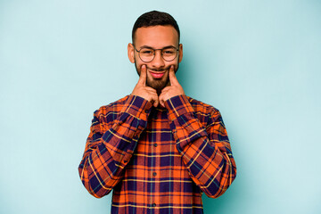 Fototapeta premium Young hispanic man isolated on blue background doubting between two options.