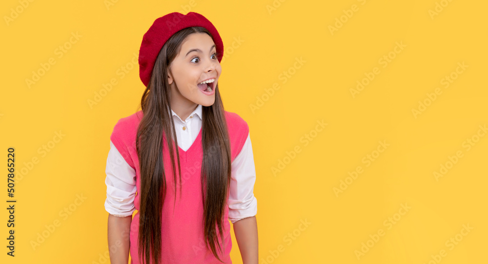 Wall mural amazed teen school girl in french beret on yellow background, amazement