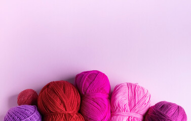 Pink red and purple knitted wool on a lilac background, hobby