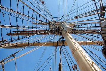 Obraz premium Ropes to control the sails, details of the device of the yacht, the mast of the sailing ship against the blue sky