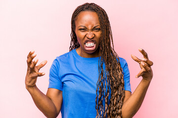 Young african american woman isolated on pink background screaming with rage.