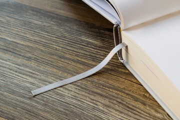 Thick hardcover book with blank pages open on wooden surface