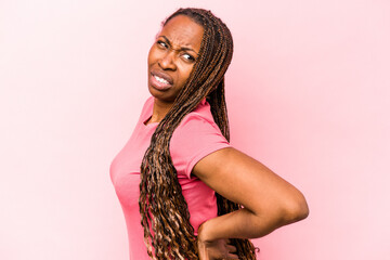 Young african american woman isolated on pink background suffering a back pain.