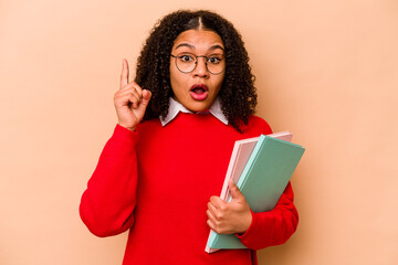 Young student African American woman isolated on beige background having an idea, inspiration concept.