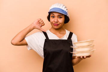 Young cook volunteer African American woman isolated on beige background feels proud and self...