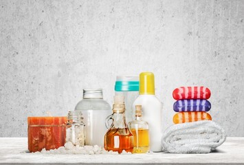 Baby accessories for bathing on table. Shampoo and shower gel bottles, towel.