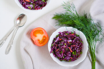 Vegetable salad of fresh red cabbage, green onions, carrots, greens on the table. Fresh dill, tomato. View from above. Healthy vegan organic meal. Vitamin treatment, nutrition. Superfood, cleansing. 