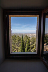 A wooden window seen from inside a room at the Parador de Jaen hotel. Beautiful views of the city of Jaen, Spain.