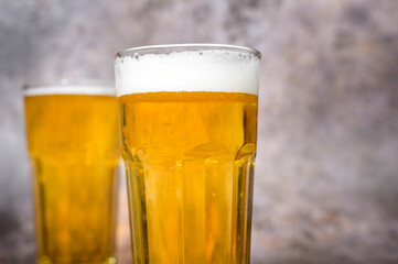 Cold craft  light Beer is pouring from bottle on wooden Table