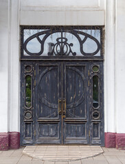 Antique door in modern style. Black painted door. Front view. Old city