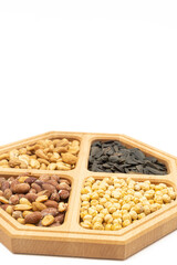 Peanuts cashew sunflower seeds and chickpea in the wooden bowl above white background