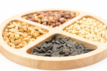 Peanuts cashew sunflower seeds and chickpea in the wooden bowl above white background