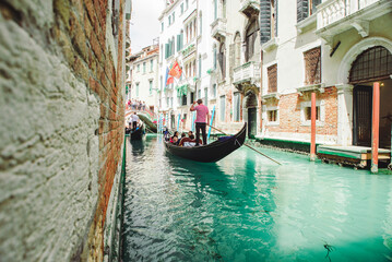 Fototapeta na wymiar Italy, Venice - May 25, 2019: people at gondola taking tour by canal