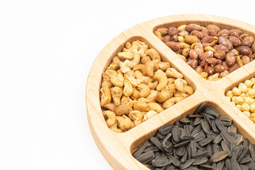 Peanuts cashew sunflower seeds and chickpea in the wooden bowl above white background