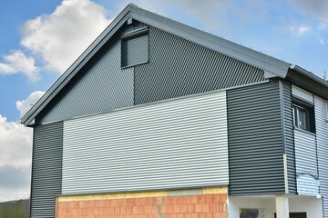 Modernes Wohnhaus mit gemauerten Wänden und Wellblech-Profil Außenverkleidung der oberen Stockwerke