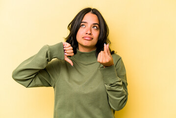 Young hispanic woman isolated on yellow background showing that she has no money.