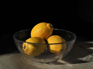 lemons in a glass bowl and black background