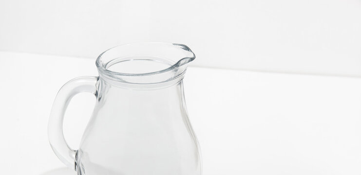 Side view of glass water jug on white background. Space for text, for advertising, banner, signboard, menu and printed materials
