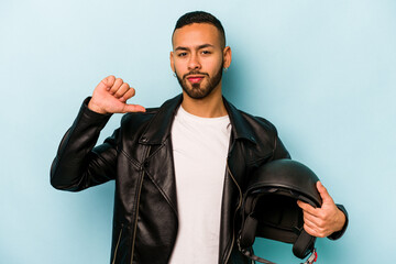 Young hispanic biker man isolated on blue background feels proud and self confident, example to...
