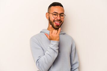 Young hispanic man isolated on white background showing rock gesture with fingers