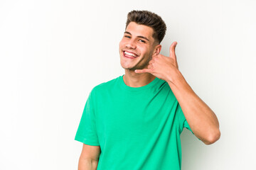 Young caucasian man isolated on white background showing a mobile phone call gesture with fingers.